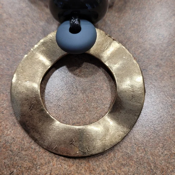 Black rope necklace with gold medal, black, and gray circle. - Picture 3 of 6